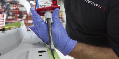 A person wearing gloves holding a red container
