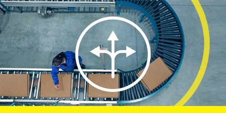 Image of a chair before a bank of readout screens with black-and-yellow stripe tape marking an arc at a social distance
