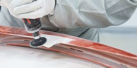 worker grinds repaired tab with roloc disc