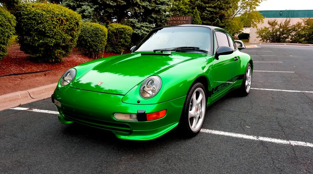 green car parked in a parking lot

