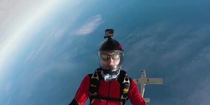 GoPro 카메라를 들고 한낮의 스카이다이버
