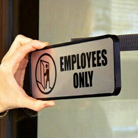 A hand holding Employees Only signage
