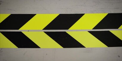 Video still of two yellow-and-black tapes next to each other, lined up so the connecting edges form arrows pointing left

