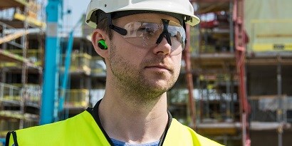 Worker wearing active hearing protection in-ear earpieces
