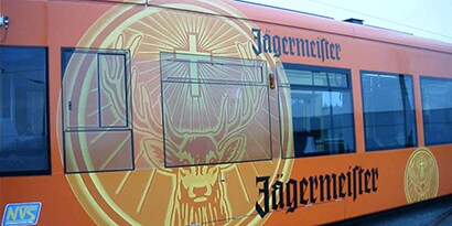 A metro transit bus wrapped with a colorful Jagermeister orange graphic using 3M perforated films.
