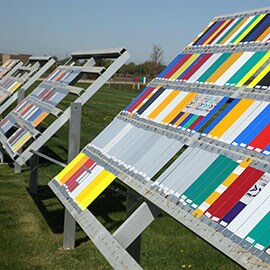 Various colors of 3M sign sheeting materials being tested outdoors for weathering standards.