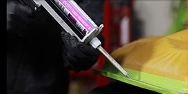 applying sealant to hem flange in car