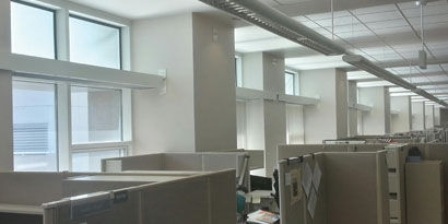Image of A room with cubicles and windows

