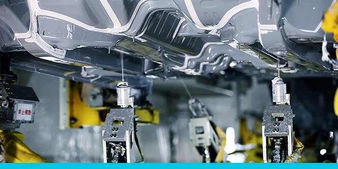 seam sealants being applied to underbody coatings of a vehicle
