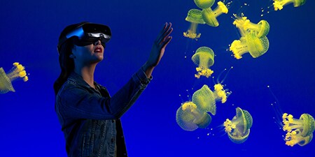 AR/VR 헤드셋으로 수중 경험을 체험하는 여성.
