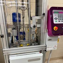 3M Instron drop tower free fall testing machine showing 3M electronics bonding solutions impact resistance.