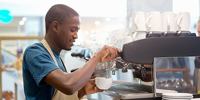 person pouring milk into a cup

