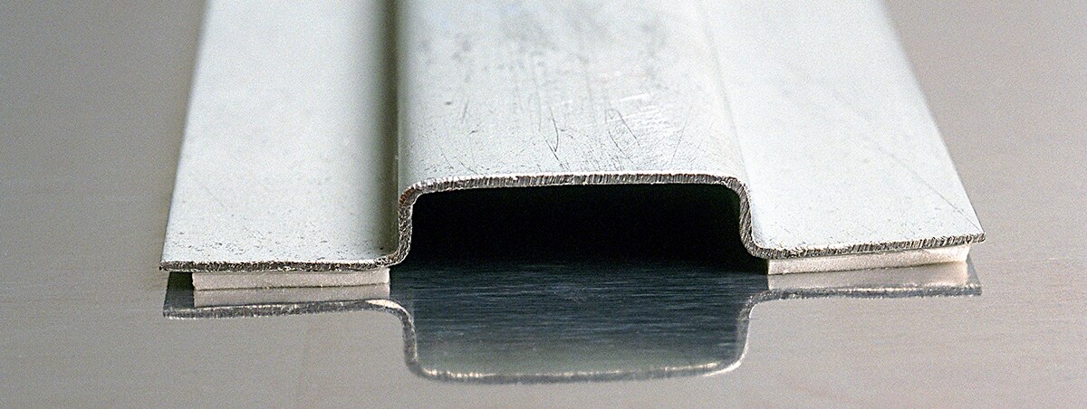 3M VHB tape shown bonding metal hatchannel adhesive joint to metal panel in industrial manufacturing application

