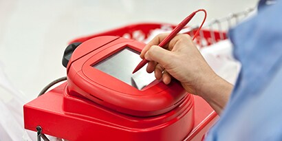 Image of a woman electronically signing for her credit card purchase at a payment terminal.
