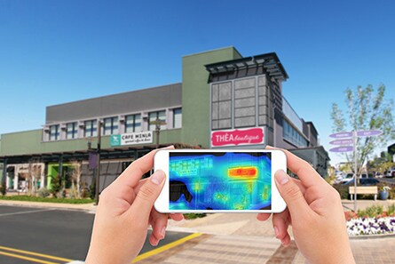 Person holding up a phone horizontally with a heat map on the phone showing how 3M Visual Attention Software works
