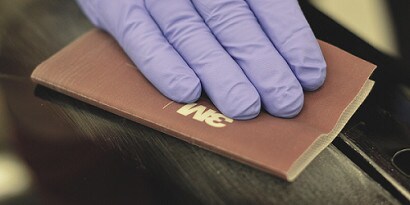 technician sanding primer with 3m flexible abrasives hand sheet
