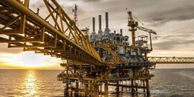 Image of an oceangoing oil drilling rig just after dawn
