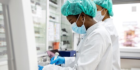 2 Scientists in lab coats working in lab
