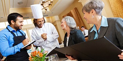chef talking to a couple of women
