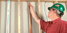 Image of an inspector reviewing the firestop around a copper pipe as it goes up through a floor penetration
