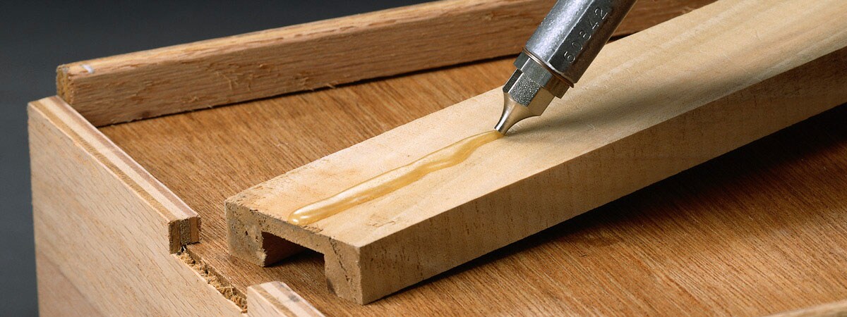 A woodworking tool with a liquid on a piece of wood
