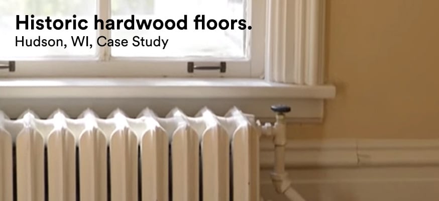 A window above an old-fashioned home radiator lets in light but rejects damaging UV rays that would damage the home’s hardwood floors.
