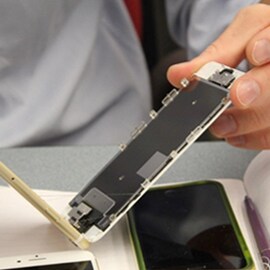 A person holding two pieces of a phone, the face and body, showing the reworkability of 3M's electronics bonding solutions.