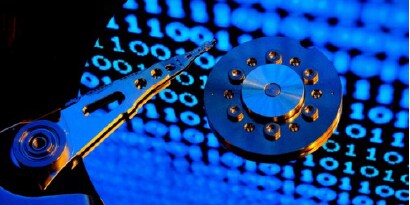 zoom in of a harddrive with binary code reflecting on the shine of the disc

