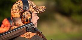 hunter in orange camo wearing comfortable ear muffs
