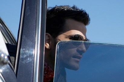 person in sunglasses looking out of a car window