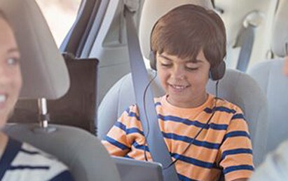 child wearing headphones and using a computer