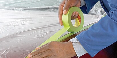 A close-up of a person's hands holding a roll of tape
