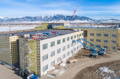 Winter image of a building complex: buildings are wrapped with 3M air barrier and exterior cladding is applied to one side