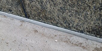 Sealed expansion joint between two different materials that may expand and contract at different rates
