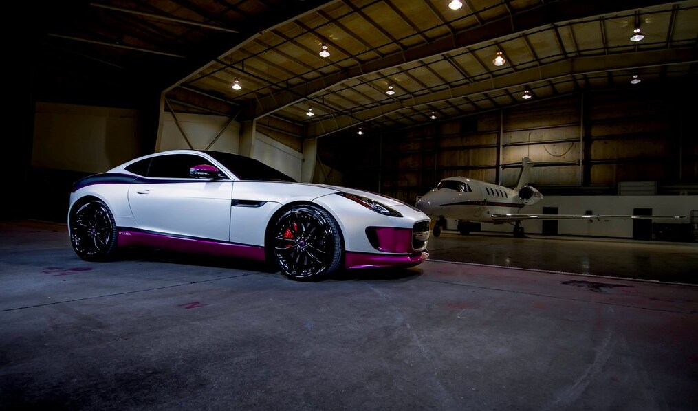 white and pink sports car in a hangar
