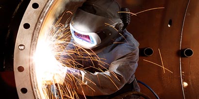 worker welding metal 
