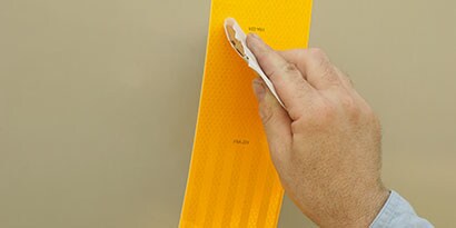 3M 반사 안전 테이프를 붙이는 남자의 손
