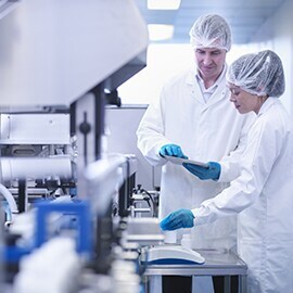 Two Scientists standing at a testing device