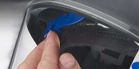 A person putting a blue tape on a tire
