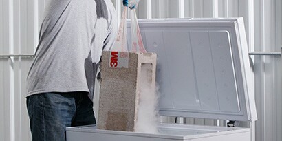 Contractor uses tape to pull a cinder block out of a freezer, showing that tape can be used in extreme conditions.
