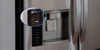 A touch panel on the front of a stainless steel refrigerator next to the water and ice dispenser is highlighted.
