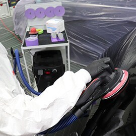 A vacuum cleaner with a white and purple handle